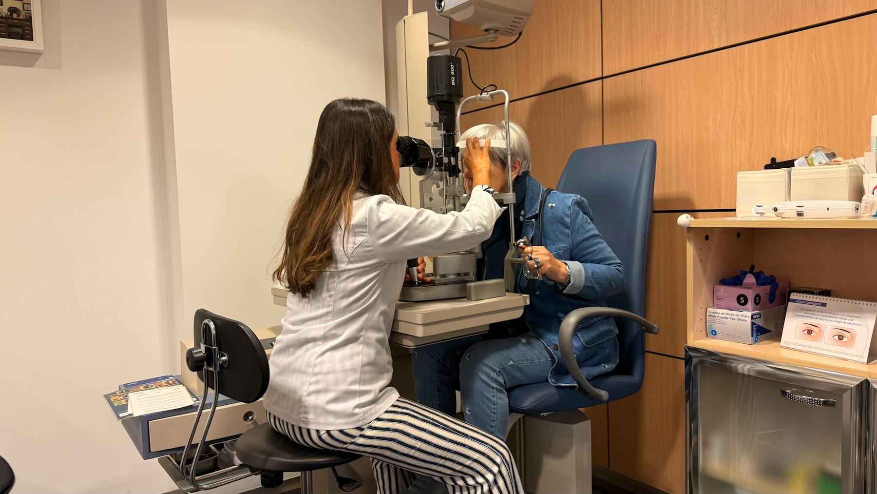 Optometrist examining a patient with a slit lamp